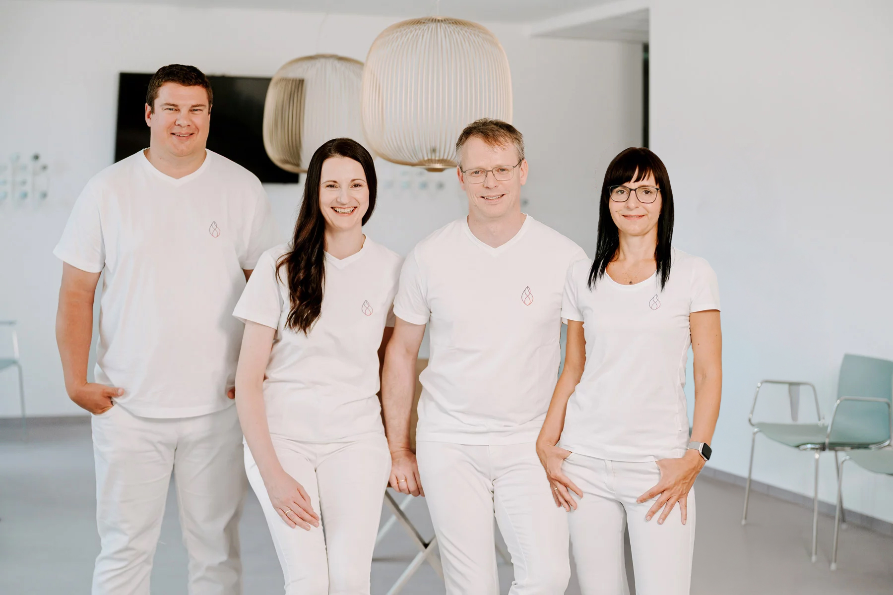 Team der Herzpraxis Magdeburg in weißer Kleidung, freundlich lächelnd im modernen Praxisumfeld.